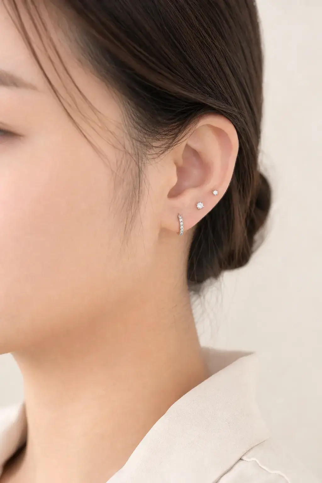 Small diamond studs worn in a layered ear stack