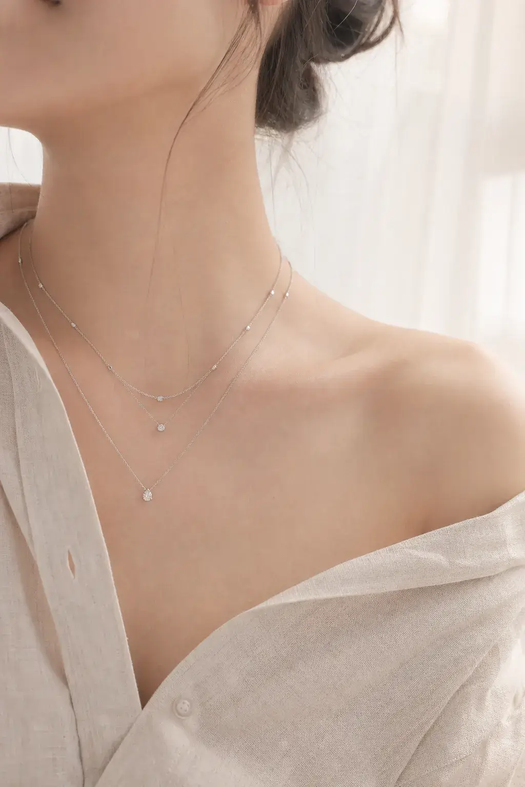 Fine chains layered at the collarbone